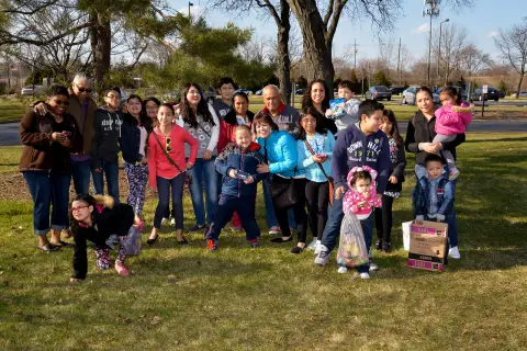 Children and CYD volunteers gathered outdoors at a spring event