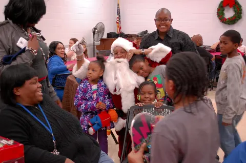 Children crowding around Santa at a CYD Holiday Toy Giveaway